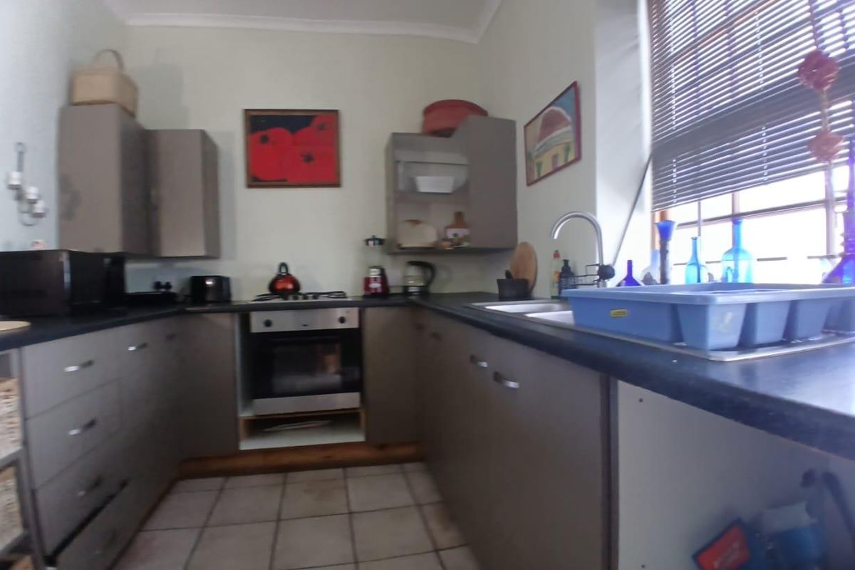 A functional kitchen featuring U-shaped cabinetry, built-in oven, gas hob, and a double sink with window views.