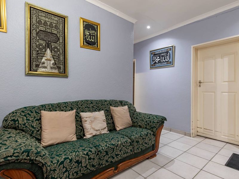 A living area featuring light blue walls, tiled flooring, and recessed ceiling lighting, providing a neutral base for interior design updates.