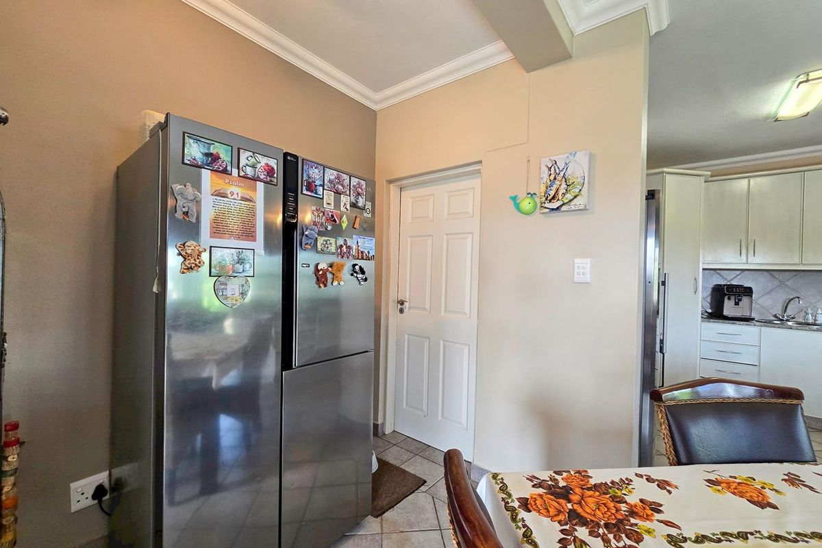 A view of the kitchen area featuring tiled flooring, neutral wall tones, and a transition into the main kitchen workspace.