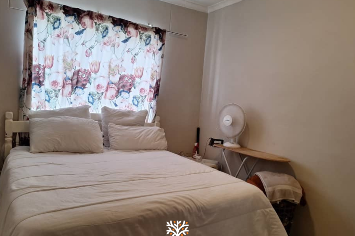 A standard bedroom featuring neutral wall finishes and tiled flooring, providing a functional space for rest.