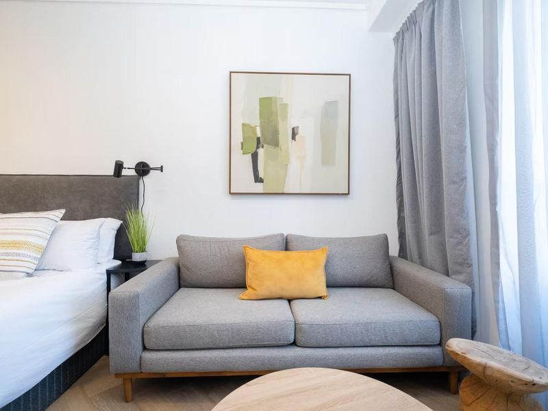 A well-appointed bedroom featuring modern herringbone flooring and a sleek wall-mounted reading light, creating a comfortable and contemporary living space.