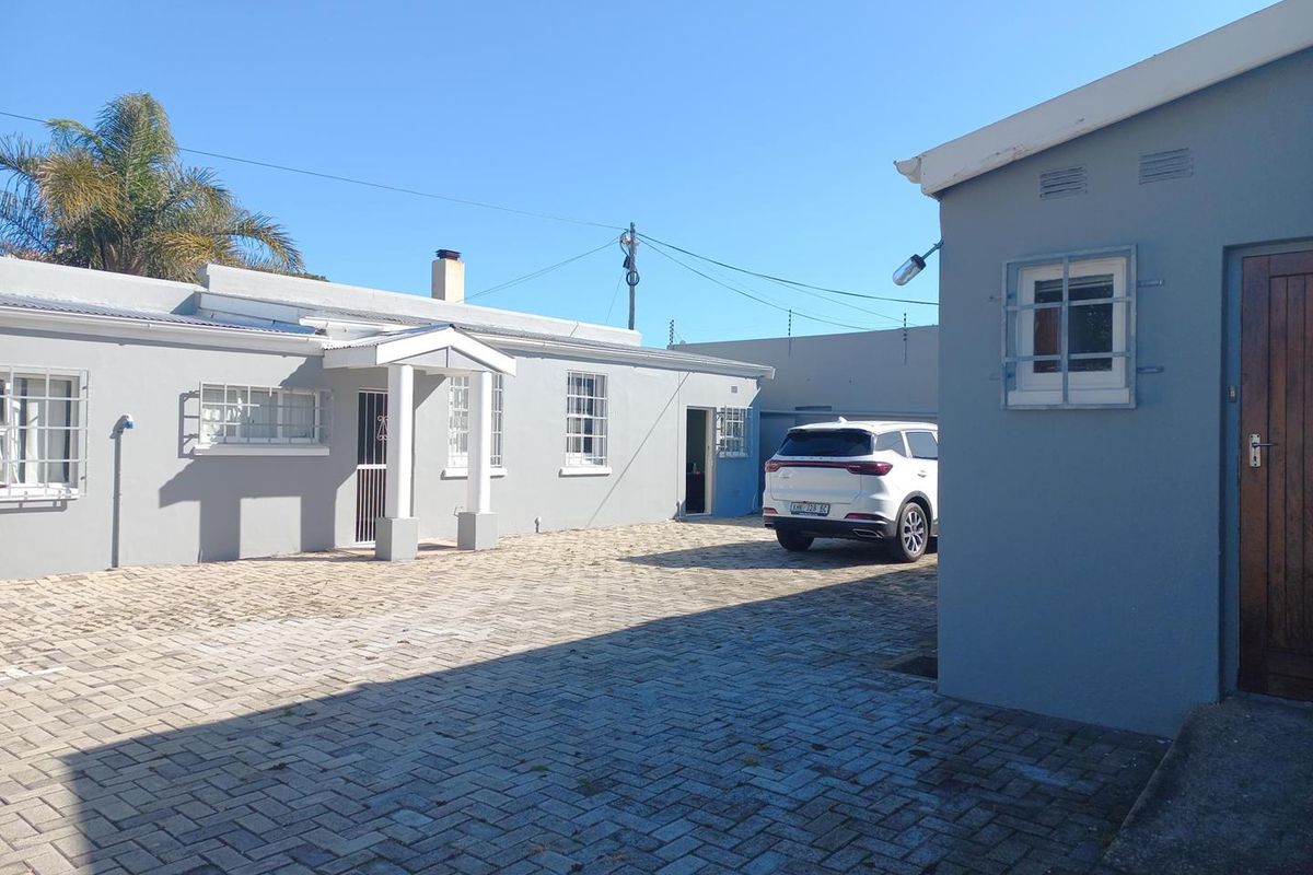 A paved courtyard area featuring office building exteriors with security bars on windows and a covered entrance.