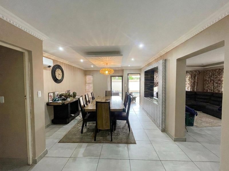 Spacious dining area featuring tiled flooring, recessed ceiling lighting, and a built-in wall niche, with direct access to the outdoor patio area.