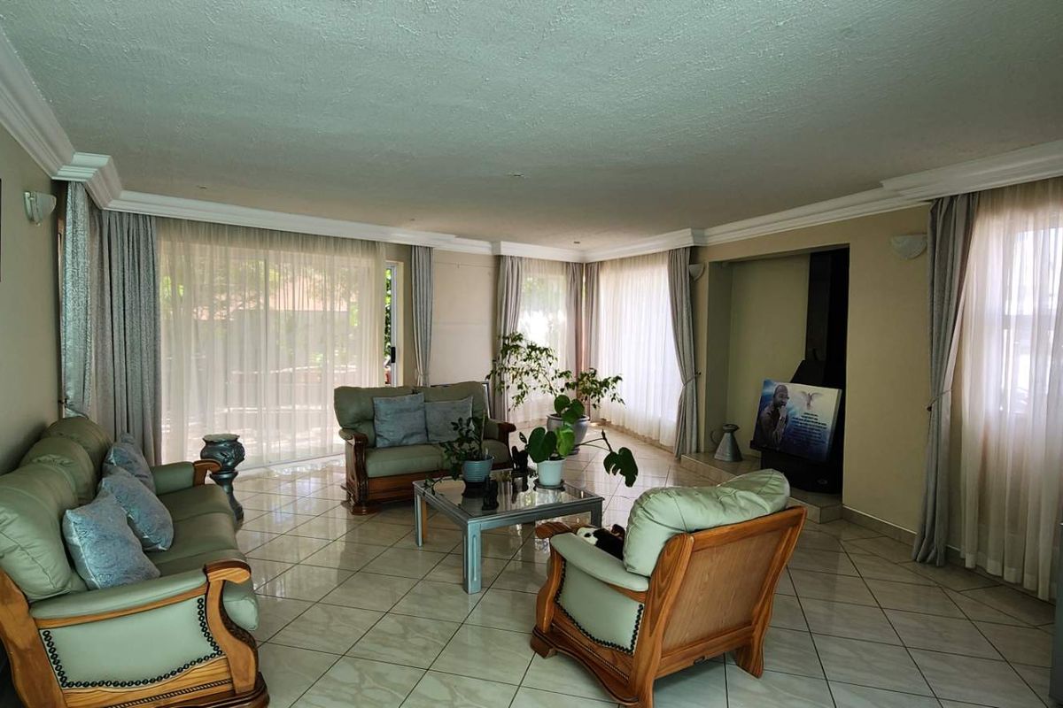 Spacious living room featuring tiled flooring, a built-in fireplace, and large sliding glass doors that provide ample natural light.