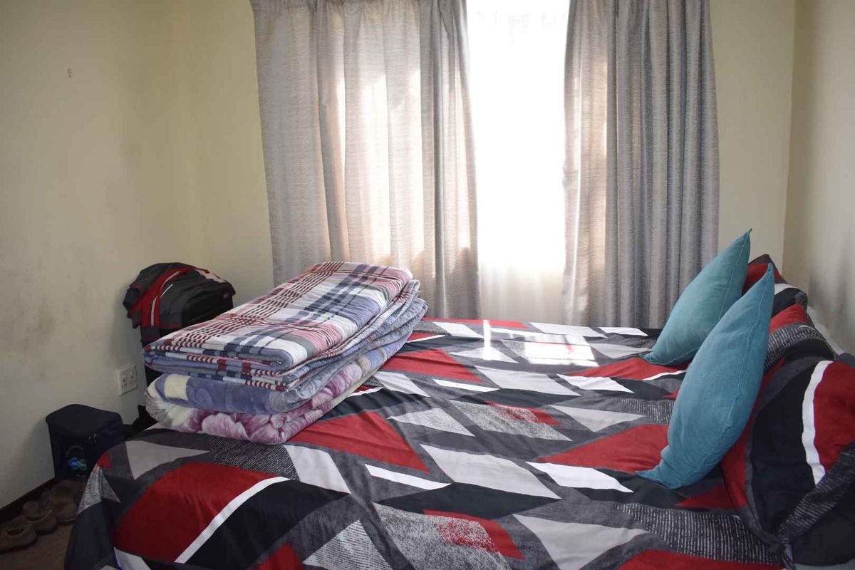 A bedroom featuring a window with curtains, providing natural light to the space.