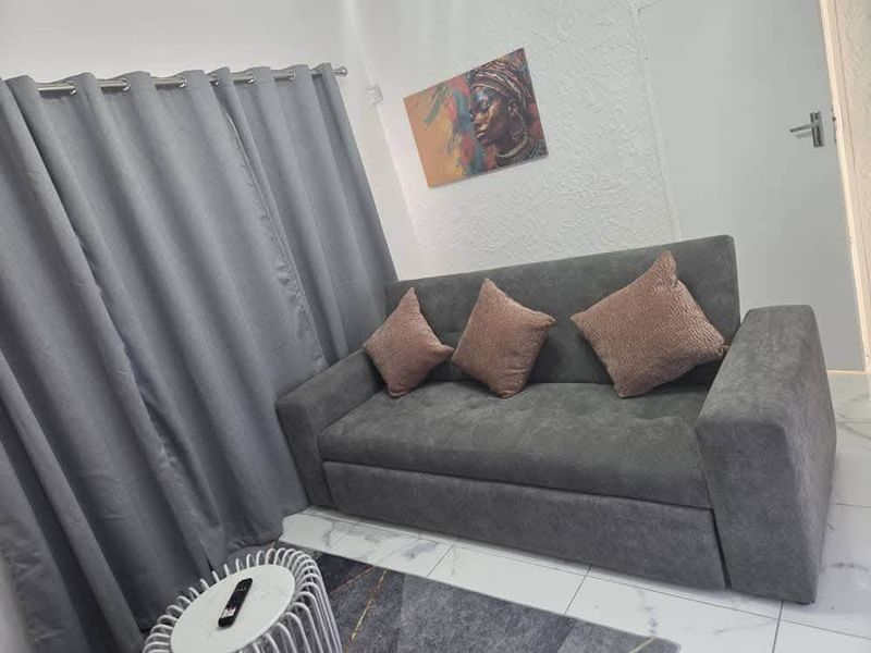 A cozy living room area featuring modern tiled flooring and textured wall finishes, creating a comfortable and inviting space.