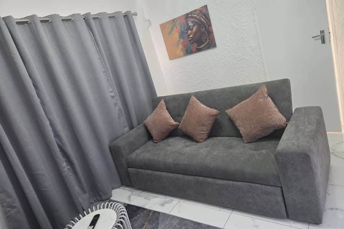 A cozy living room area featuring modern tiled flooring and textured wall finishes, creating a comfortable and inviting space.