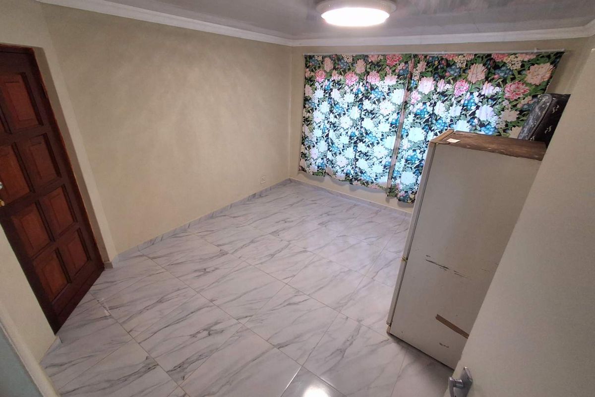 A bedroom featuring marble-look floor tiles, crown molding, and a wooden door, providing a neutral foundation for interior design.
