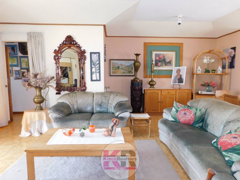 A living room featuring tiled flooring and a vaulted ceiling, offering a traditional layout with neutral wall tones.