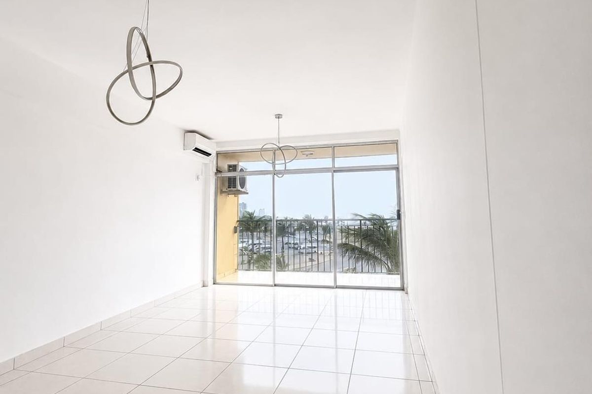 A bright, empty living area featuring tiled floors, modern pendant lighting, a split-system air conditioner, and large sliding glass doors leading to a balcony.
