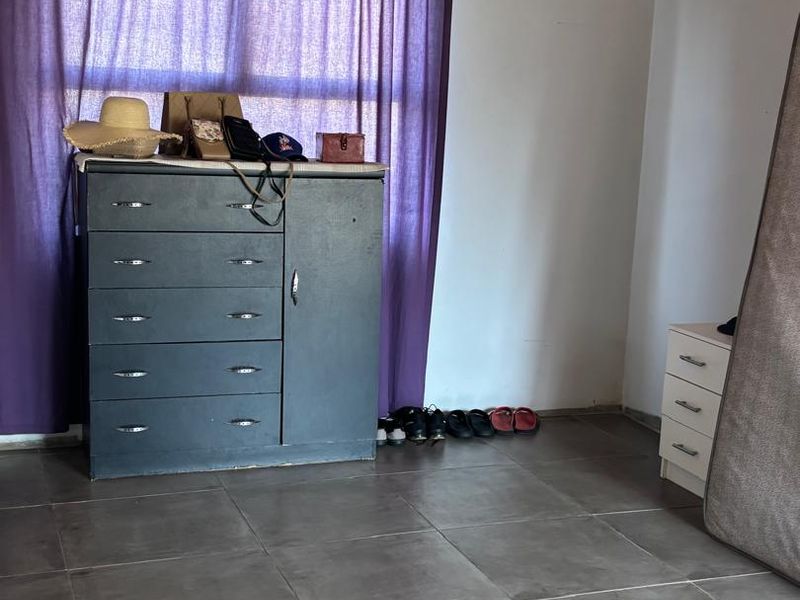 A bedroom featuring tiled flooring and a timber ceiling, currently used for storage.