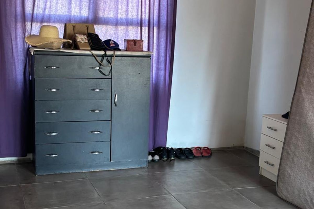 A bedroom featuring tiled flooring and a timber ceiling, currently used for storage.