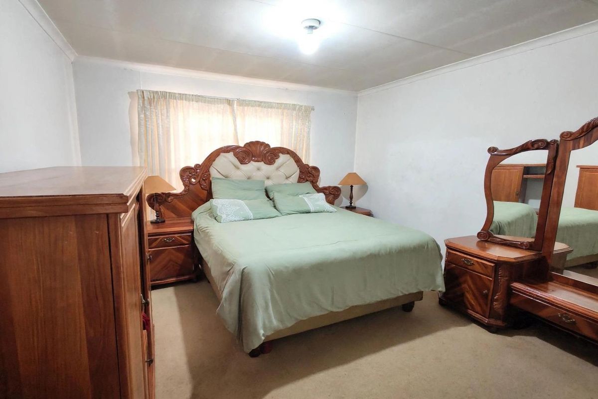 A standard bedroom featuring carpeted flooring and neutral wall finishes, providing a functional and comfortable sleeping space.