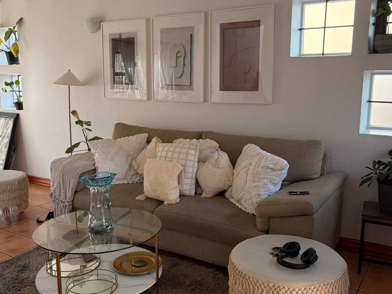 A cozy living room featuring terracotta floor tiles and grid-pane windows, creating a warm and inviting atmosphere.