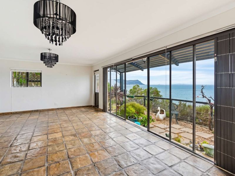 Spacious living area featuring large sliding glass doors that open to a scenic coastal view and provide abundant natural light.