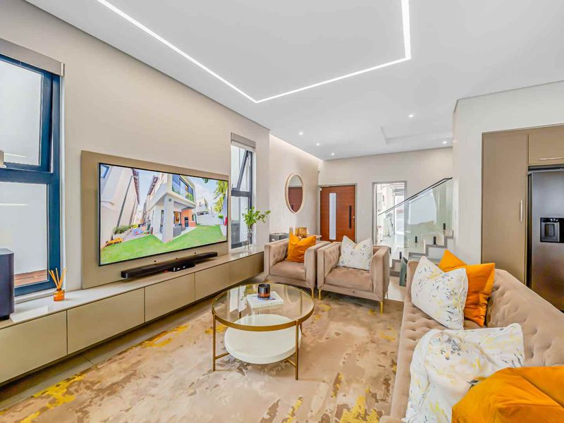 Modern living room featuring a sleek built-in media console, recessed ceiling lighting, and high-quality finishes with an open-plan layout.