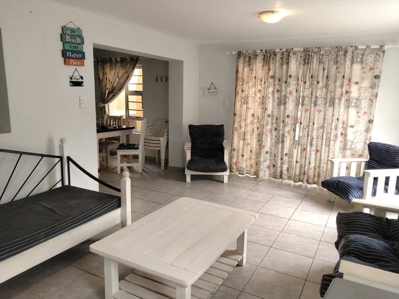 Open plan living area featuring tiled flooring and large sliding glass doors leading to an outdoor space.