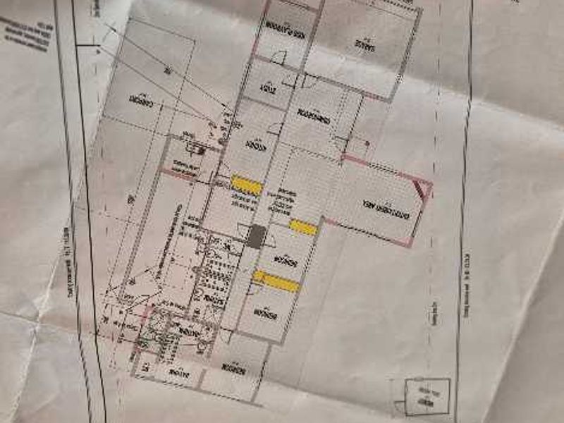 A printed architectural floor plan showing the layout of the house, including the garage, living areas, bedrooms, and outdoor pool.