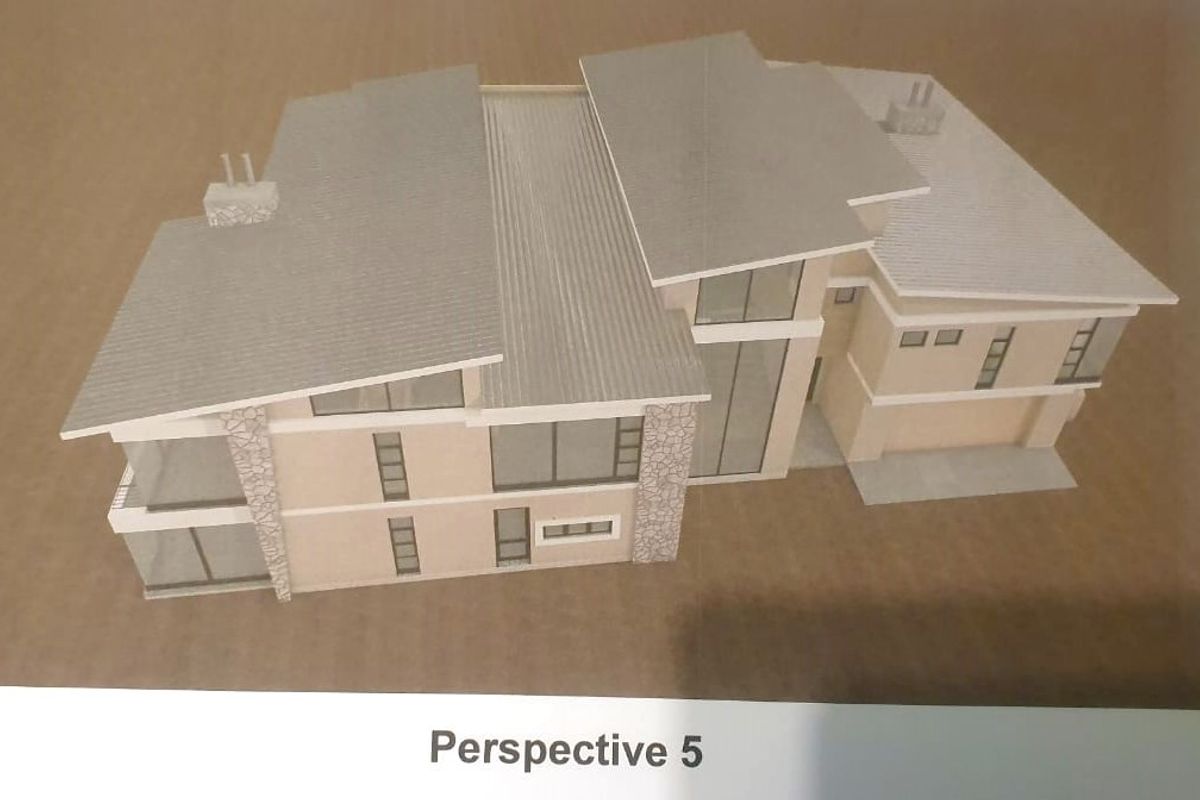 A scale architectural model showing the exterior design of a modern multi-level house with stone accents and a pitched metal roof.