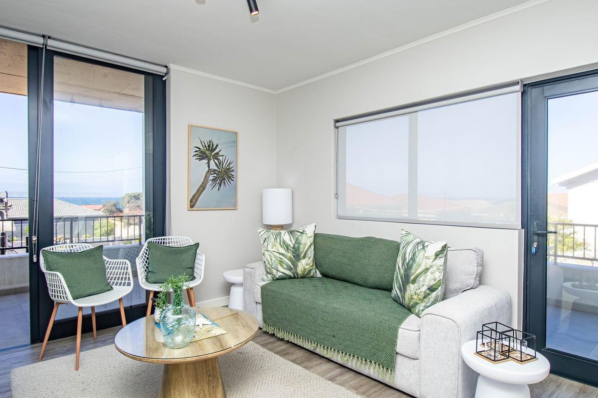 Bright living room featuring large glass sliding doors leading to a balcony, providing natural light and access to outdoor space.