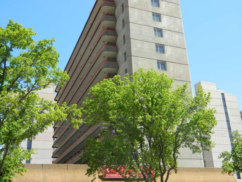 Exterior view of a multi-story apartment building featuring a concrete facade and multiple balconies.