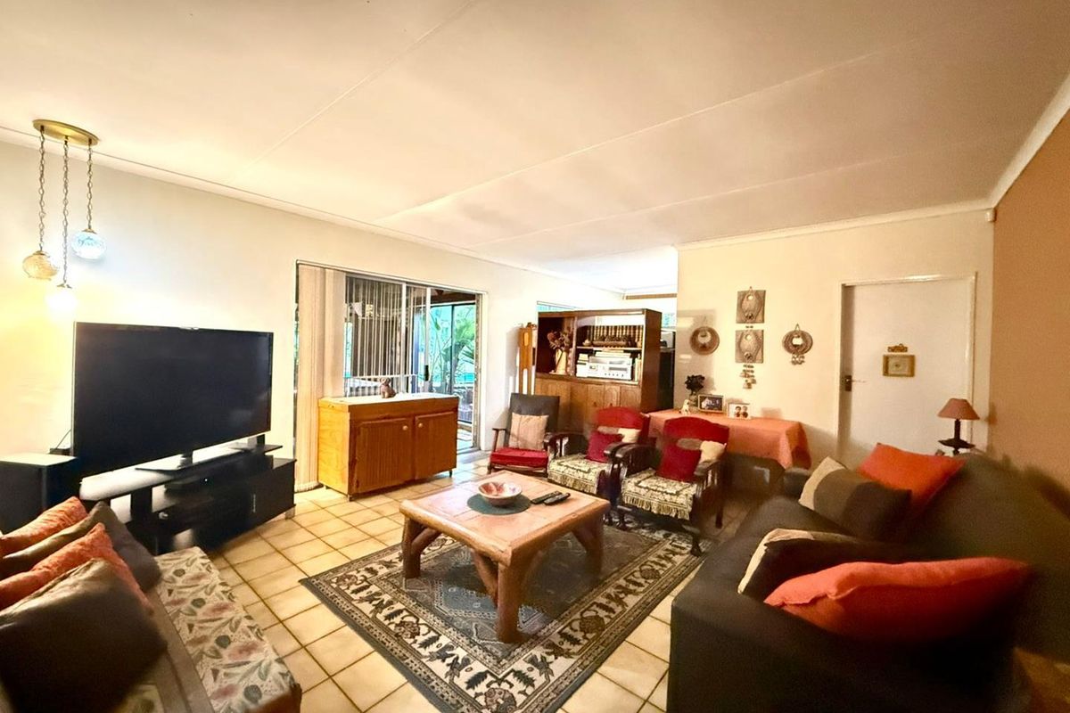 Spacious living room featuring ceramic floor tiles and sliding glass doors providing direct access to the outdoor patio area.