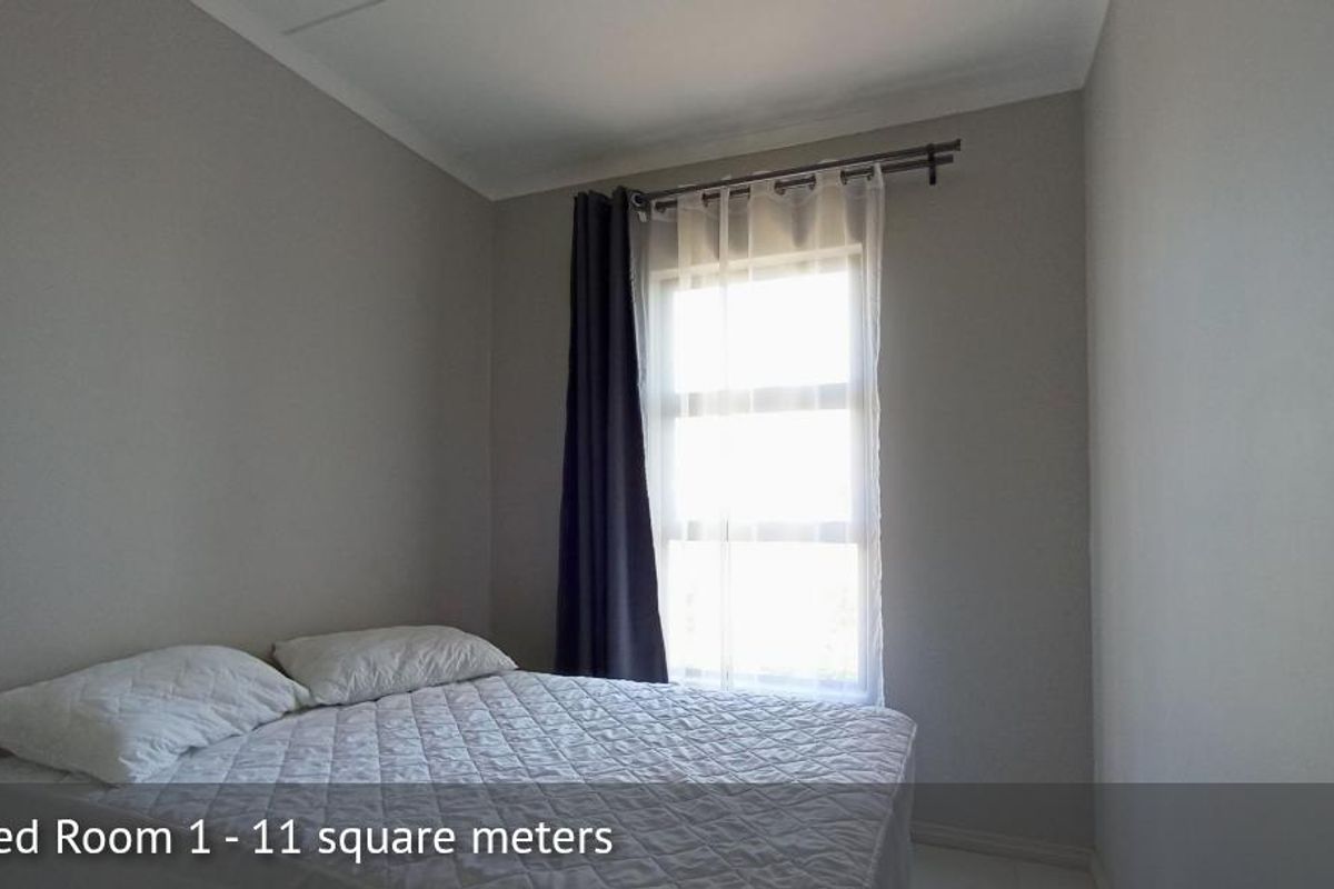 A bedroom featuring neutral wall tones, a window with curtain rod, and tiled flooring.
