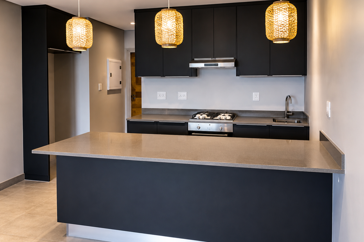 Modern kitchen featuring sleek black cabinetry, stone countertops, a gas hob with extractor fan, and a central island, finished with contemporary lighting.