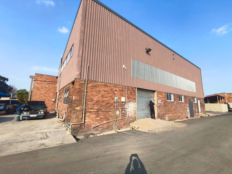 Industrial property featuring a face brick and corrugated metal facade with a roller shutter door and concrete apron access.