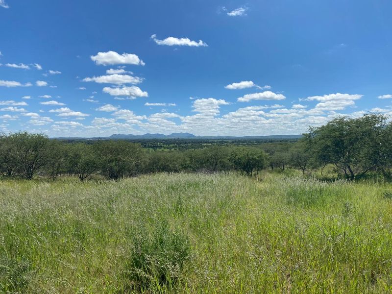 A scenic view of the expansive natural landscape and rolling hills, showcasing the property's open terrain and surrounding environment.