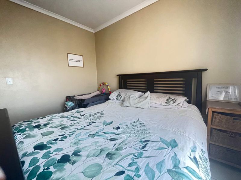 A standard bedroom featuring neutral wall finishes and decorative cove cornicing.