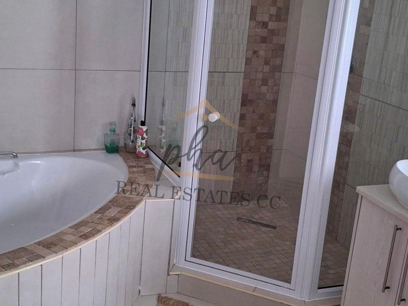 Modern bathroom featuring a built-in bathtub, separate glass shower enclosure, and a vanity with a vessel sink.