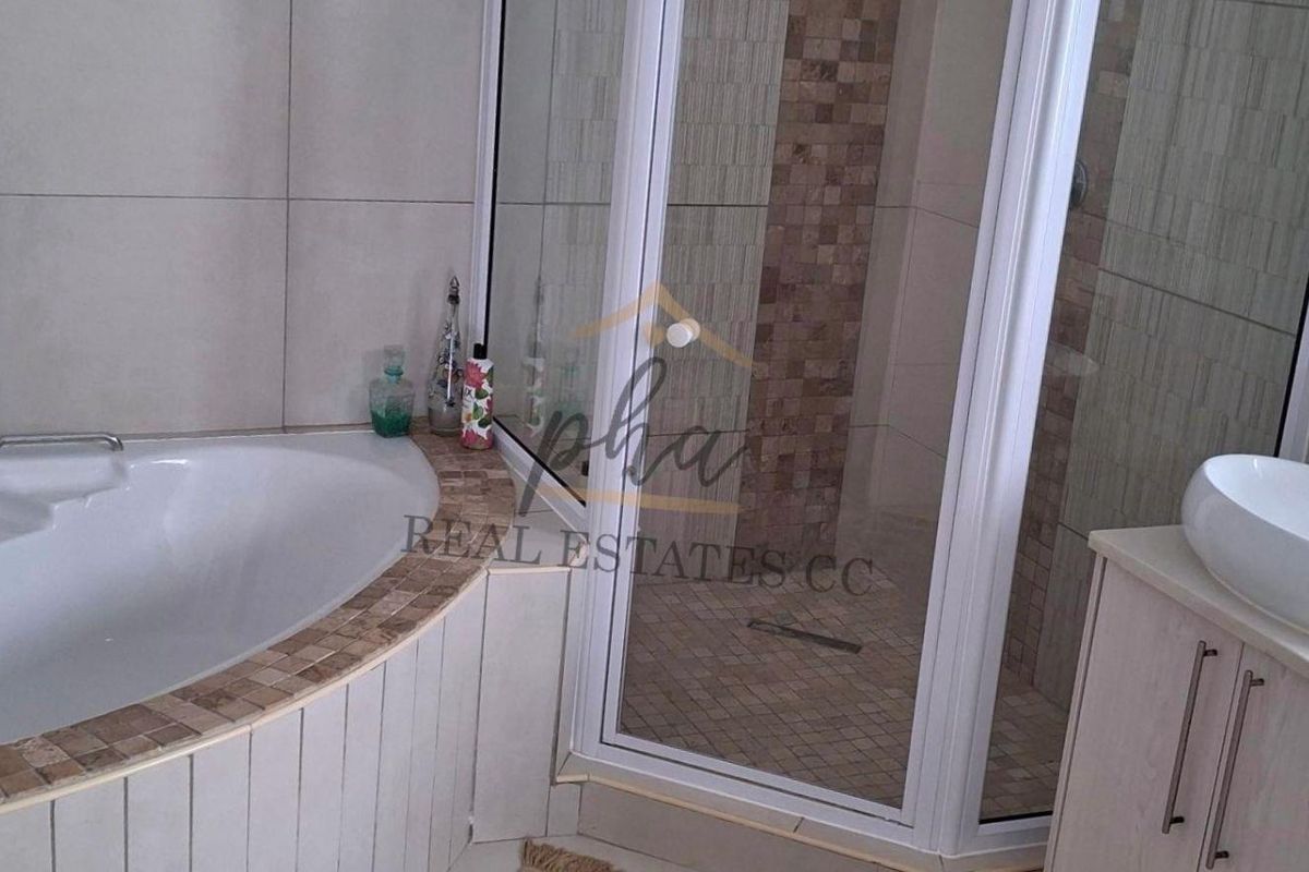 Modern bathroom featuring a built-in bathtub, separate glass shower enclosure, and a vanity with a vessel sink.
