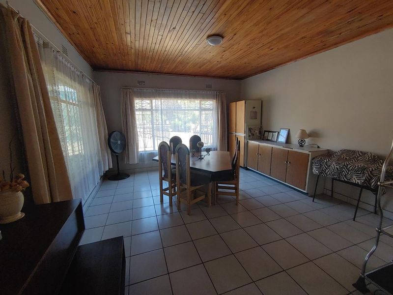 Dining room featuring tiled flooring and a classic wooden tongue and groove ceiling, providing a functional space for family meals.