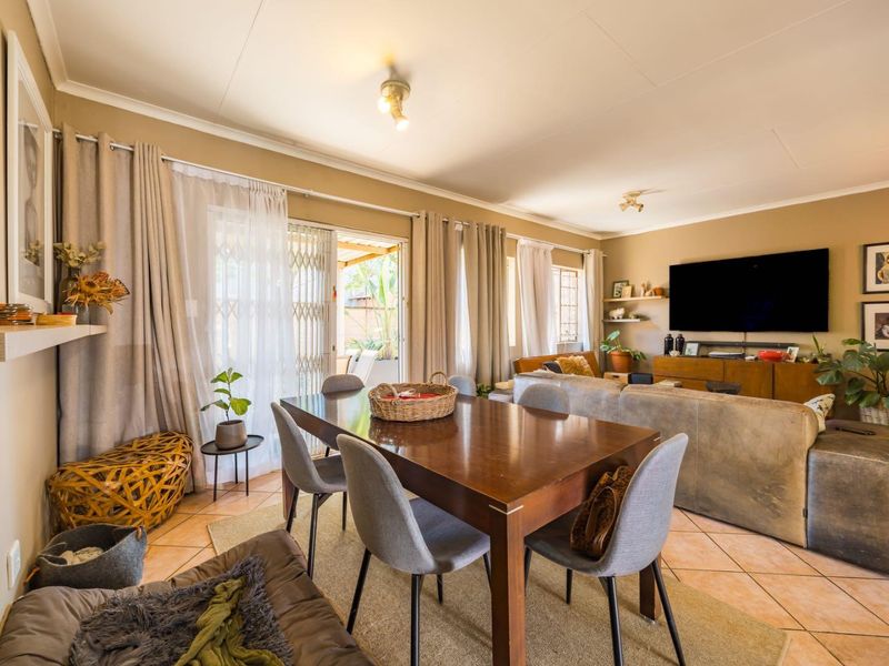 Spacious open-plan living and dining area featuring tiled flooring and a sliding glass door providing access to the outdoor patio.
