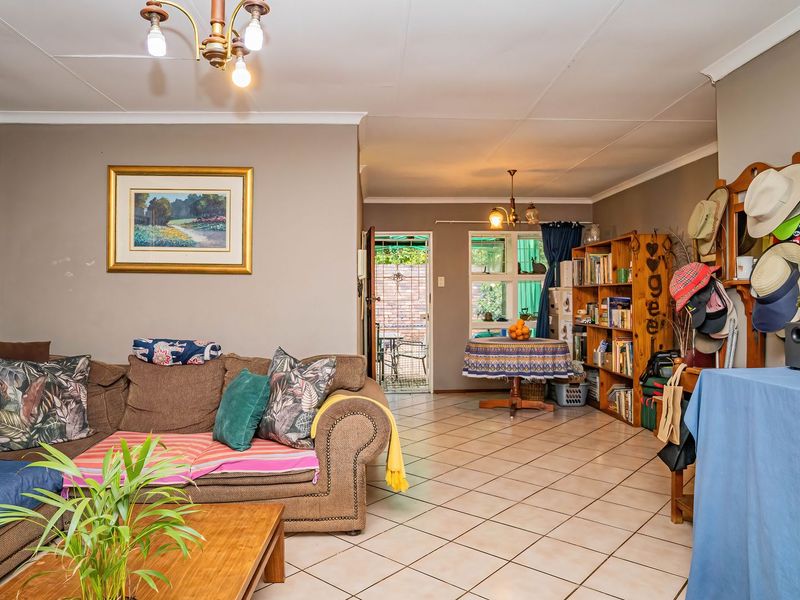 Open-plan living and dining area featuring tiled flooring, coved ceilings, and direct access to an outdoor patio space.