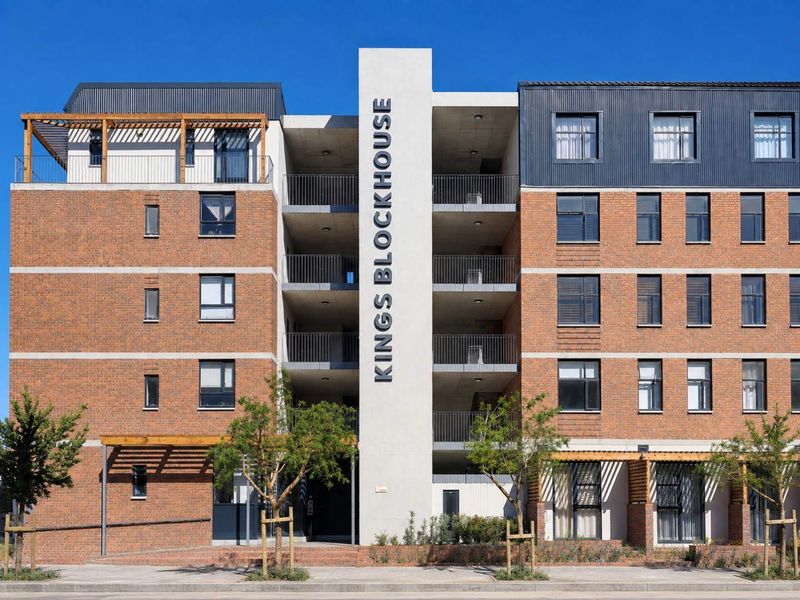 Front elevation of the Kings Blockhouse apartment building, featuring a modern brick and concrete facade with integrated balconies and timber pergola details.
