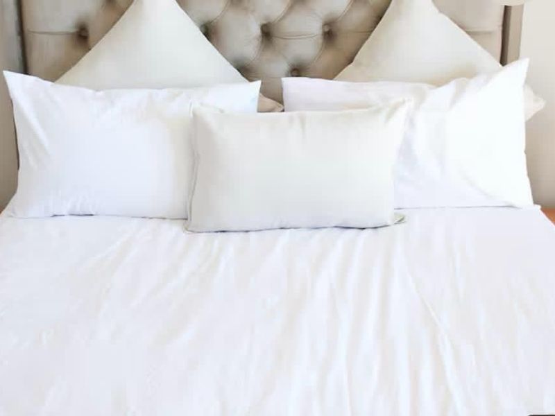 A close-up view of a bedroom featuring a tufted headboard and bedside tables.