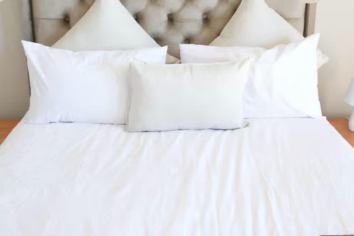 A close-up view of a bedroom featuring a tufted headboard and bedside tables.