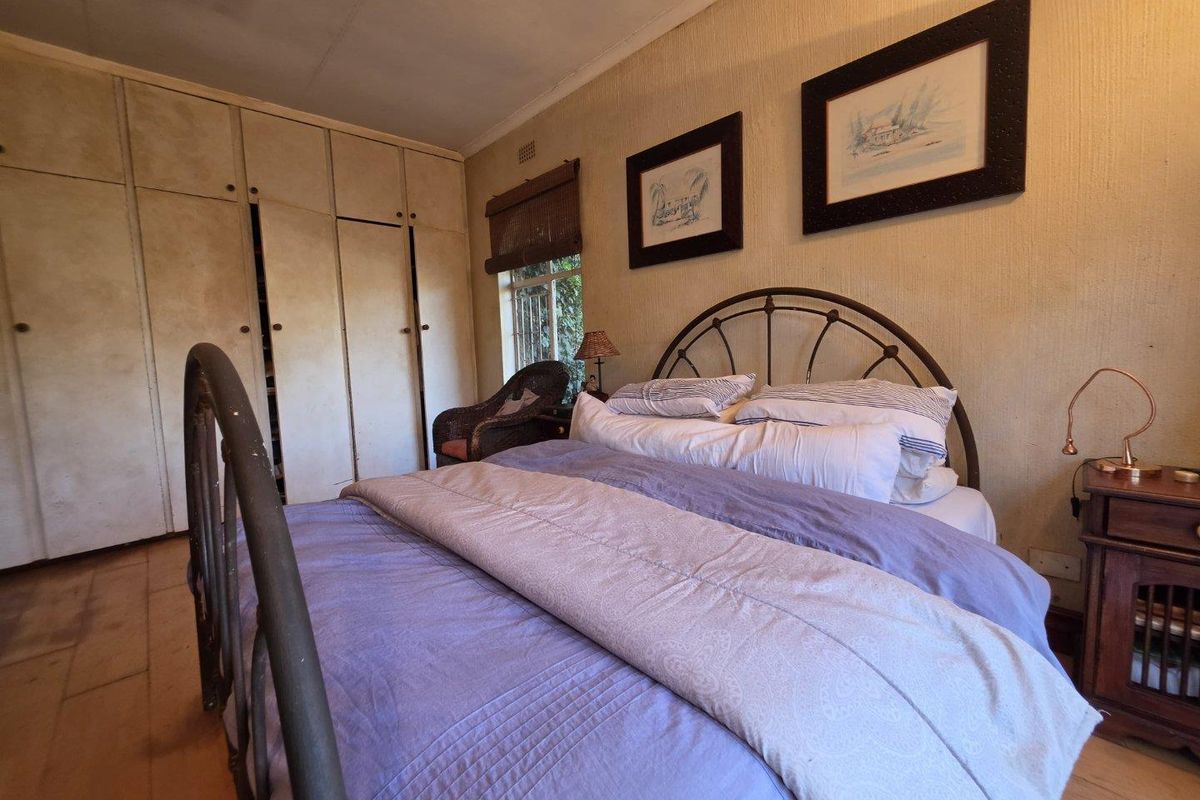 A bedroom featuring built-in floor-to-ceiling wardrobes and textured wall finishes.