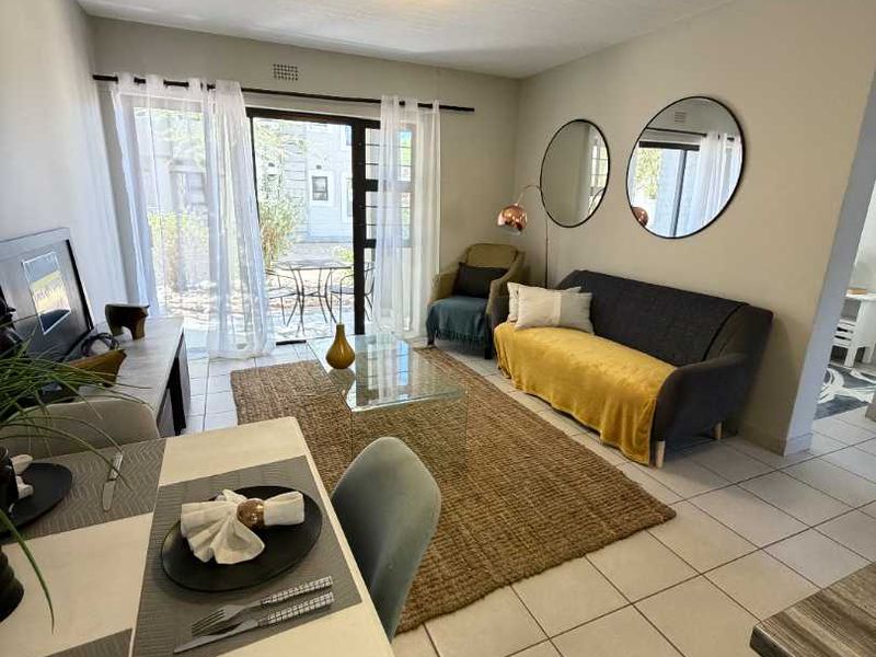 Open plan living and dining area featuring tiled flooring and a sliding glass door providing access to an outdoor space.