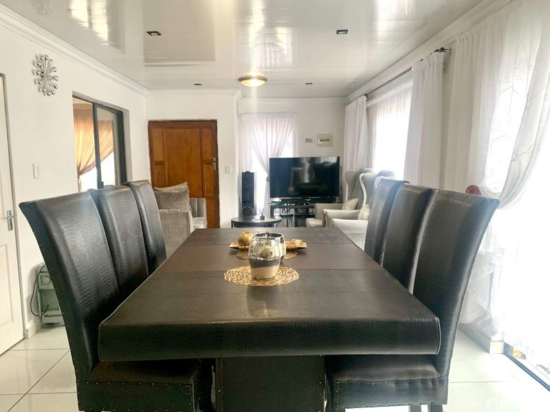 A dining room featuring glossy ceiling finishes, recessed lighting, and tiled flooring, with a sliding door providing access to the exterior.