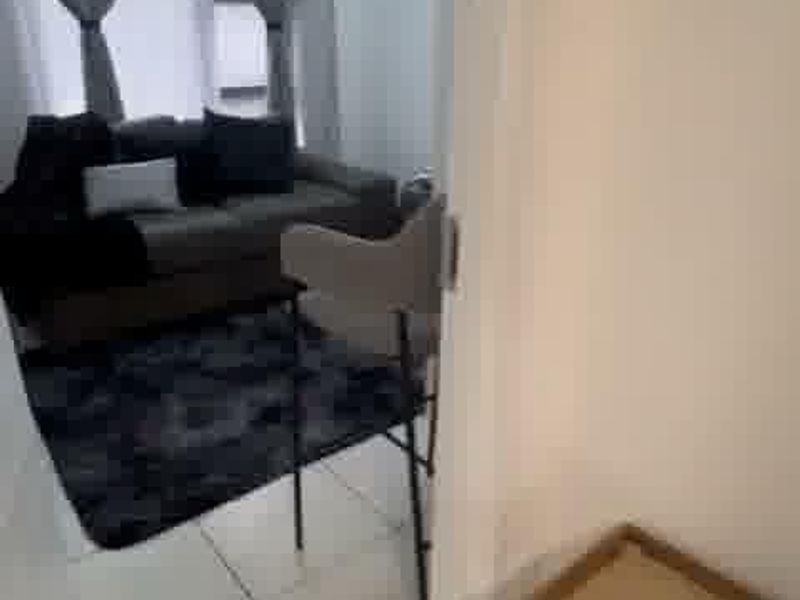 A view into a living room area featuring tiled flooring and a window, captured from an adjacent space.