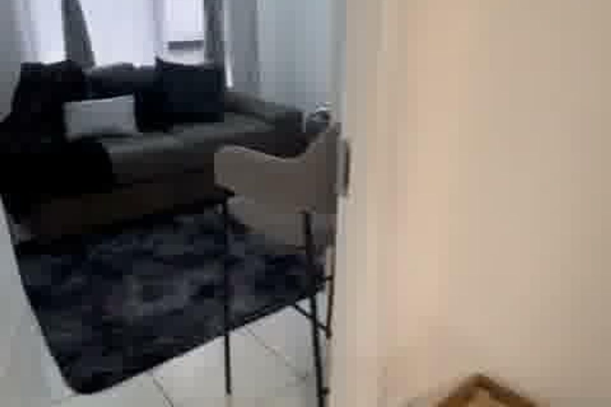 A view into a living room area featuring tiled flooring and a window, captured from an adjacent space.