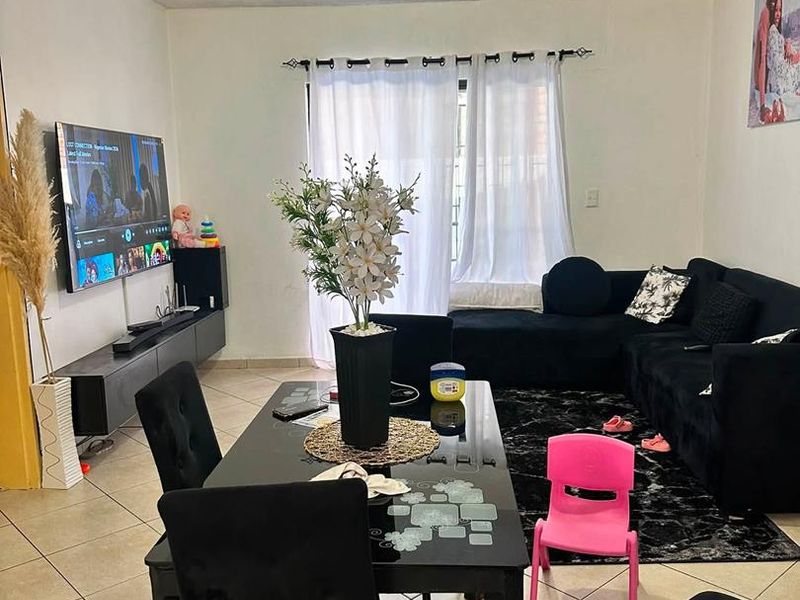 Open plan living and dining area featuring tiled flooring and access to a balcony through a sliding glass door.
