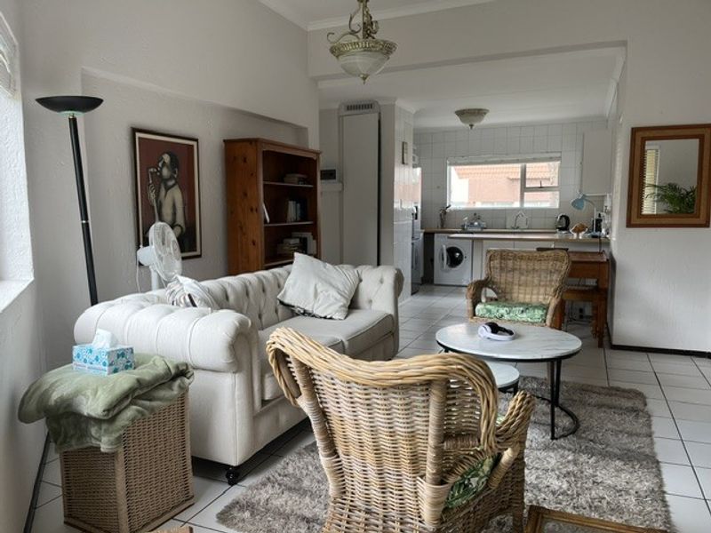 Open plan living and kitchen area featuring tiled flooring and functional kitchen cabinetry, offering a versatile space for daily living and dining.