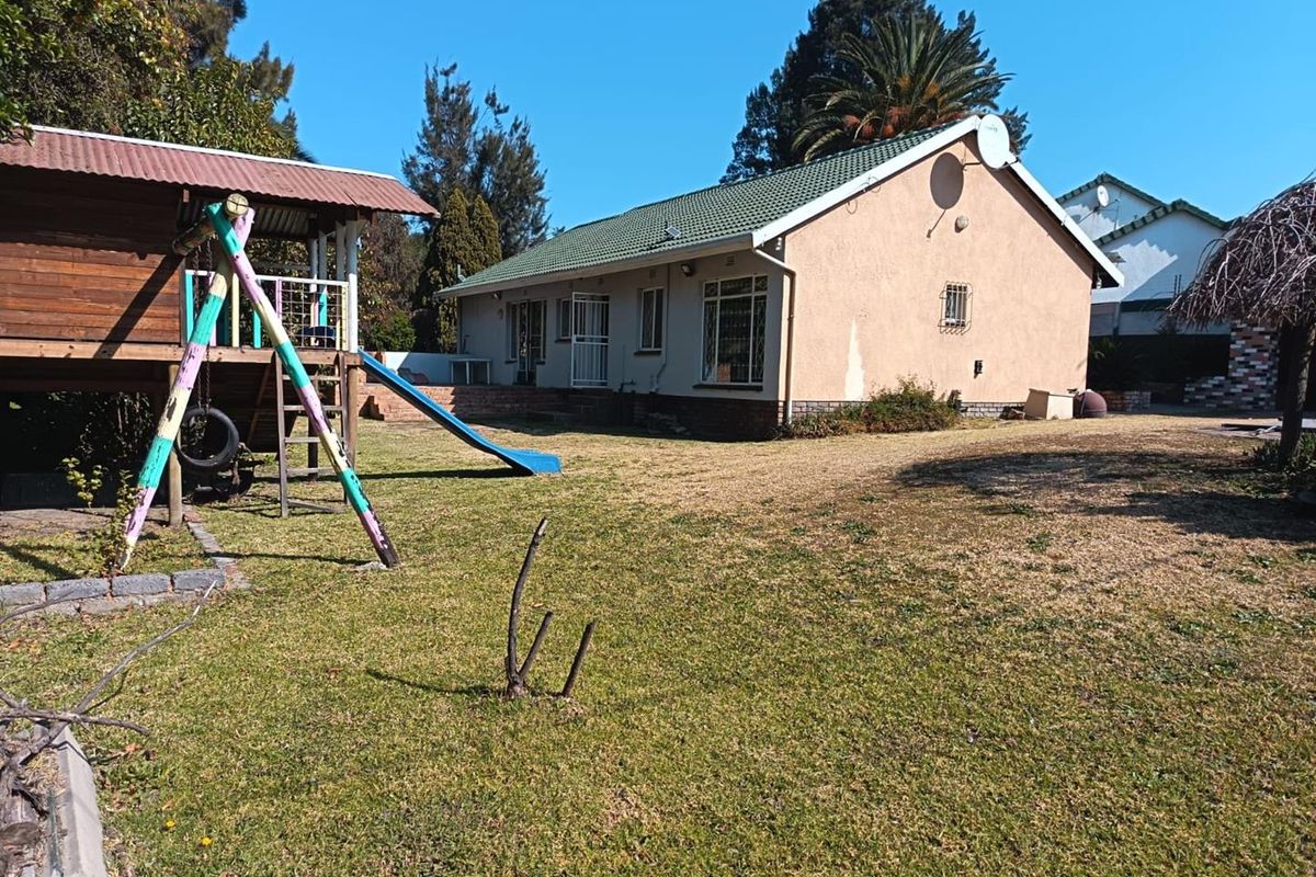 Rear view of the house showing the garden area, tiled roof, and exterior wall finishes.