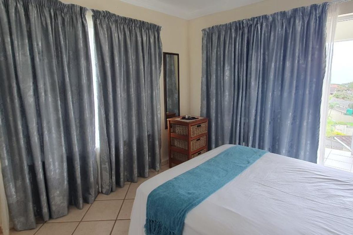 A bedroom featuring tiled flooring and direct access to a private balcony through sliding glass doors, offering natural light and outdoor connectivity.