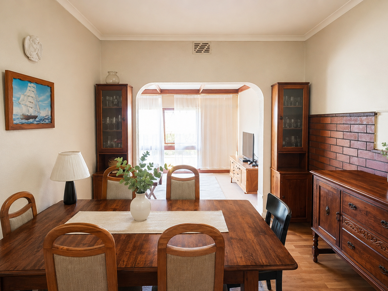 A dining room featuring a brick accent wall, coved ceilings, and an open archway leading into an adjacent living area.