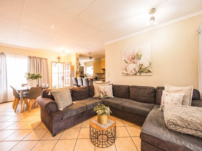 Spacious open-plan living and dining area featuring tiled flooring, recessed lighting, and a seamless flow into the adjacent kitchen space.